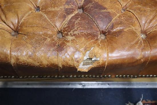 A pair of leather tan wing armchairs